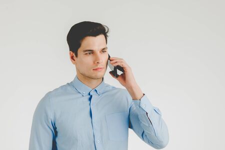 Young hipster man confident and serious talking on phone for business work,  portrait isolated on white background.の写真素材