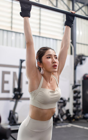 Asian young female fit strong body sporty athletic fitness model in sport bra legging and gloves...