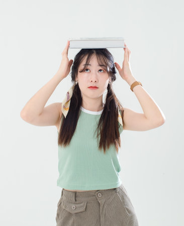 Portrait isolated cutout studio shot of Asian young cool female teenage fashion model with pigtails braids hairstyle in casual trendy shirt shorts standing posing look at camera on white background.の写真素材