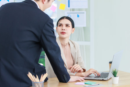 Asian professional successful female businesswoman operator helping desk call center wearing stereo headset and microphone in formal business wear talking answering question from online customer.の写真素材
