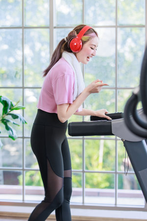 Asian young pretty cheerful happy healthy fitness girl in sexy sportswear with headphones listening...