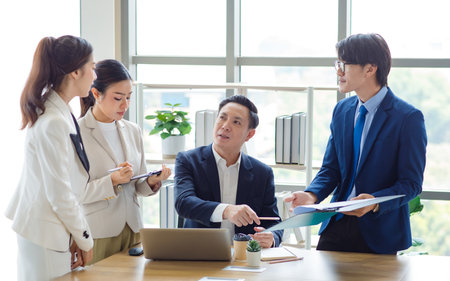 Group of Asian stressed depressed worried tired professional successful female businesswomen and male businessmen employees in formal business suit arguing disagreement about strategy in meeting room.の写真素材