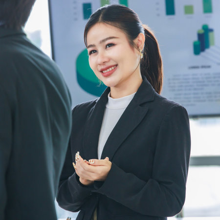 Closeup shot Asian professional successful female businesswoman employee in formal business suit standing smiling clapping hands applauding greeting thank you lecturer in company office meeting room.の写真素材