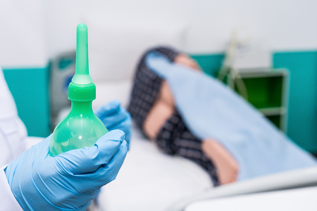 Doctor gives her patient for enema to resolve constipation problem.の写真素材