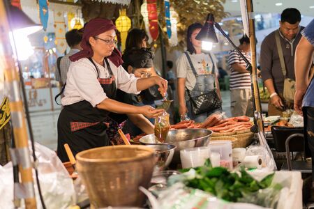 Mega Bangna Shopping Center, Bangkok, Thailand - August 5, 2017: Thai female local food vendor are food scoop bag for customers who buy food to eat at home.のeditorial素材