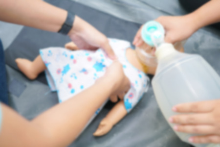 Blurry Background of People are trained to rescue a baby by a child CPR Doll and Ambu Bag.の写真素材