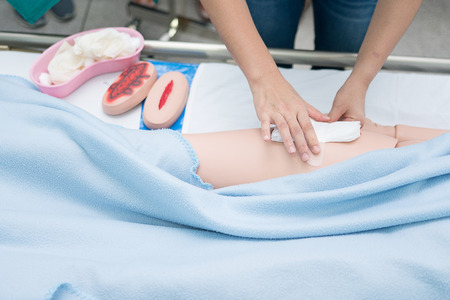 Nursing student were trained how to wound care patient. She practice training with the Doll of...