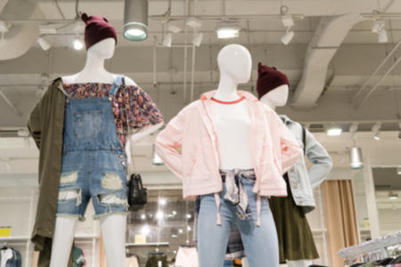 Blurry Background of Puppet showing luxury fashion clothing in department store.