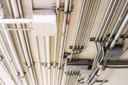 Blurry Background of Ceiling of pipe wire telephone line, and receiver box within the mall.
