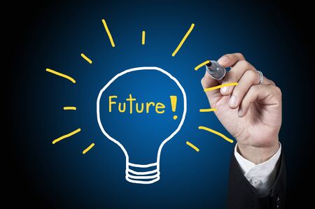 Hand with pen drawing future in the lamp on whiteboardの写真素材