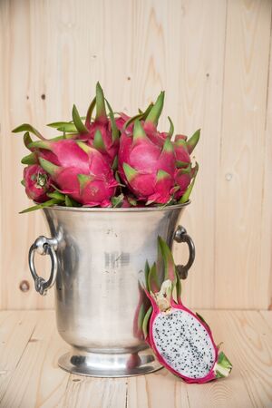 Dragon Fruit in Metallic bucket on Wooden Backgroundの写真素材