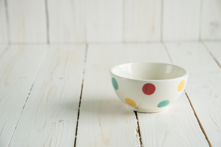 Colorful Ceramic Bowls on White Wooden Backgroundの写真素材