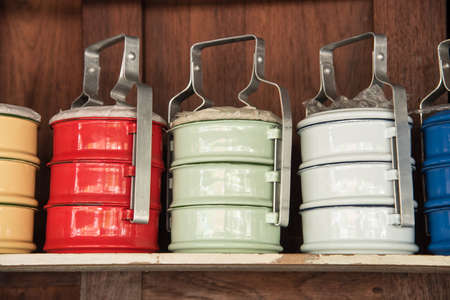Colorful zinc tiffin on wooden shelvesの写真素材