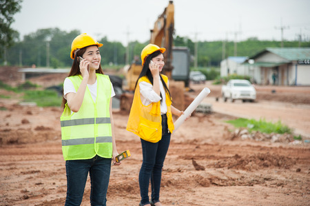 Two womens engineers using smart phone in a construction siteの写真素材