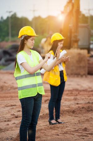 Two women engineers using smart phone in a construction siteの写真素材