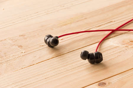 Red Earphone on Wooden Boardの写真素材