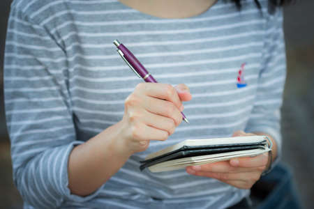 Asian women writing into the notebook by right handの写真素材