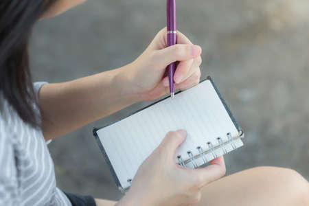 Asian women writing into the notebook by right handの写真素材