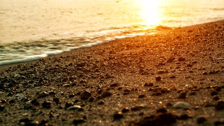 The waves crashing on the beach at sunrise can be seen up close