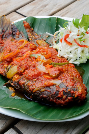 Gurami Panggang Sambal Plecing or Grilled Gurami Fish with Plecing Spicy Sauce served in Banana Leafの写真素材