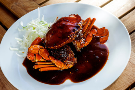 Crab with black pepper seasoning served on a white plateの写真素材