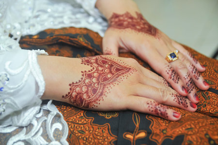 two hands decorated with henna art at a traditional Javanese wedding, Indonesiaの写真素材