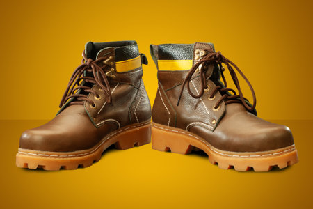 A Pair of Protective semi-boots designed for safety and durability in yellow backgroundの写真素材