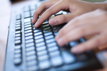 close up of hands typing on a computer keyboard