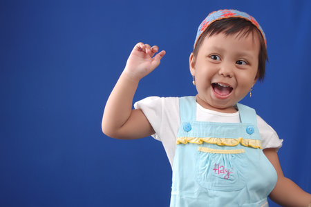 an Indonesian little girl wearing headband with pose so cute and excitedの写真素材