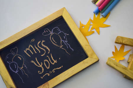 text miss you on the chalkboard and colorful chalk,autumn leaf origami. White backgroundの写真素材