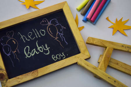 Word "Hello baby" written on blackboard with colorful chalkの写真素材