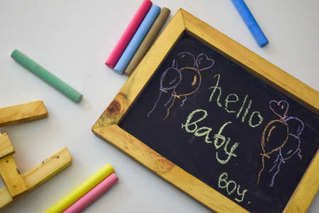 Word "Hello baby" written on blackboard with colorful chalkの写真素材
