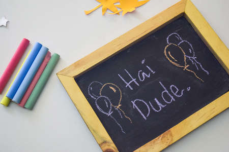 text hai dude on the chalkboard and colorful chalk,autumn leaf origami. White backgroundの写真素材