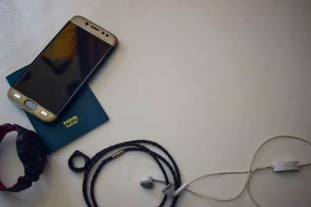 Passport, hand phone, watches, bracelet and are lying on white background. Preparing for travelingの写真素材