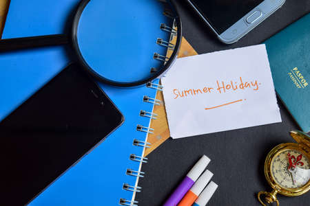 Travel Concept Inspiration - Summer Holiday on paper. passport, magnifying glass, Compass, Smartphone, book on black backgroundの写真素材