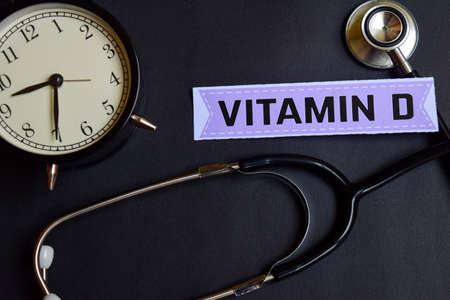 Vitamin D on the paper with Healthcare Concept Inspiration. alarm clock, Black stethoscope.の写真素材