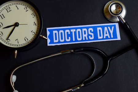 Doctors Day on the paper with Healthcare Concept Inspiration. alarm clock, Black stethoscope.の写真素材
