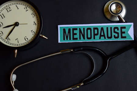 Menopause on the paper with Healthcare Concept Inspiration. alarm clock, Black stethoscope.の写真素材