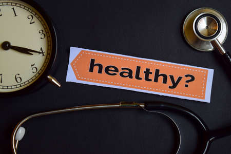 Healthy? on the print paper with Healthcare Concept Inspiration. alarm clock, Black stethoscope.の写真素材