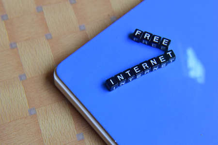 concept of Free Internet on wooden cubes with books in backgroundの写真素材