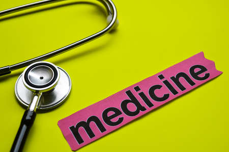 Closeup medicine with stethoscope concept inspiration on yellow backgroundの写真素材