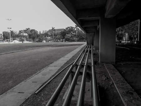 a seat on the edge of the football field. Black and white