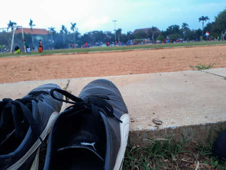 a pair of black running shoes on display on the soccer fieldの写真素材