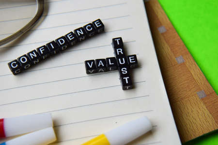 Confidence - value trust message written on wooden blocks. education and motivation concepts. Cross processed image on green Backgroundの写真素材