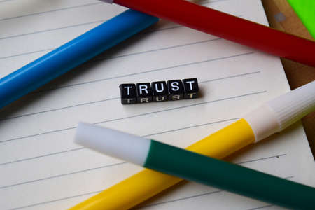 Trust message written on wooden blocks. education and motivation concepts. Cross processed image on green Backgroundの写真素材