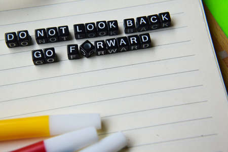 Don't look back go forward message written on wooden blocks. education and motivation concepts. Cross processed image on green Backgroundの写真素材