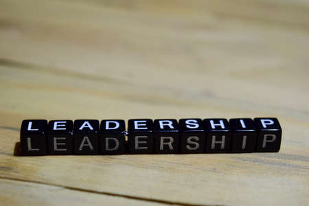 Leadership message written on wooden blocks. education and motivation concepts. Cross processed image on Wooden Backgroundの写真素材