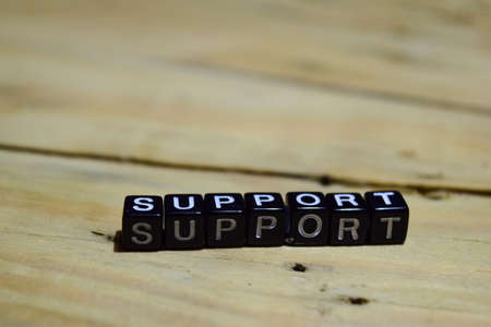 Support message written on wooden blocks. education and motivation concepts. Cross processed image on Wooden Backgroundの写真素材