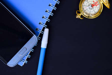 Notebook, smartphone, compass and pen with black background, for business presentation ror adding your listの写真素材