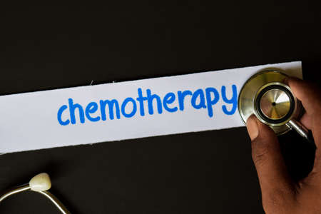 Conceptual image with Chemotherapy inscription with the view of stethoscope, in someone hand with black background. Medical Conceptual.の写真素材